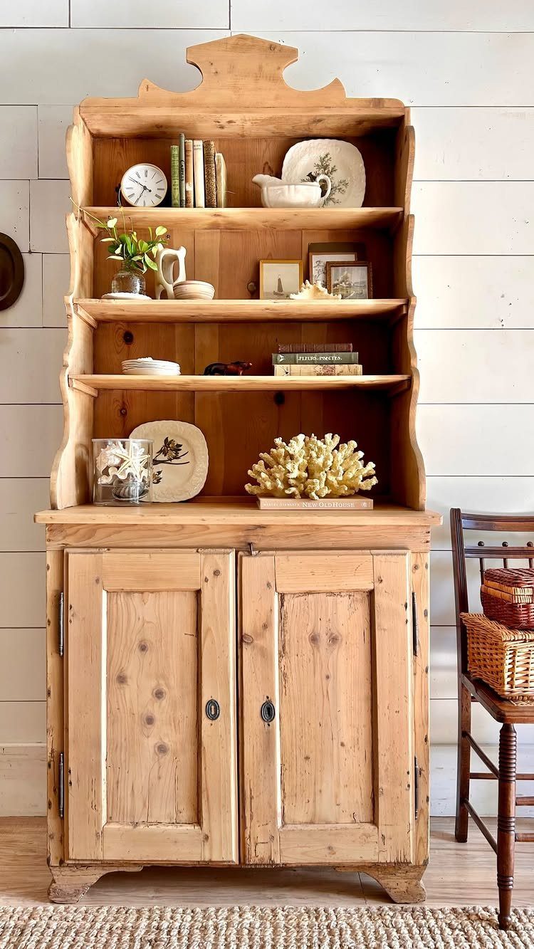 Rustic pine wood hutch with open shelves and lower cabinets against white walls.