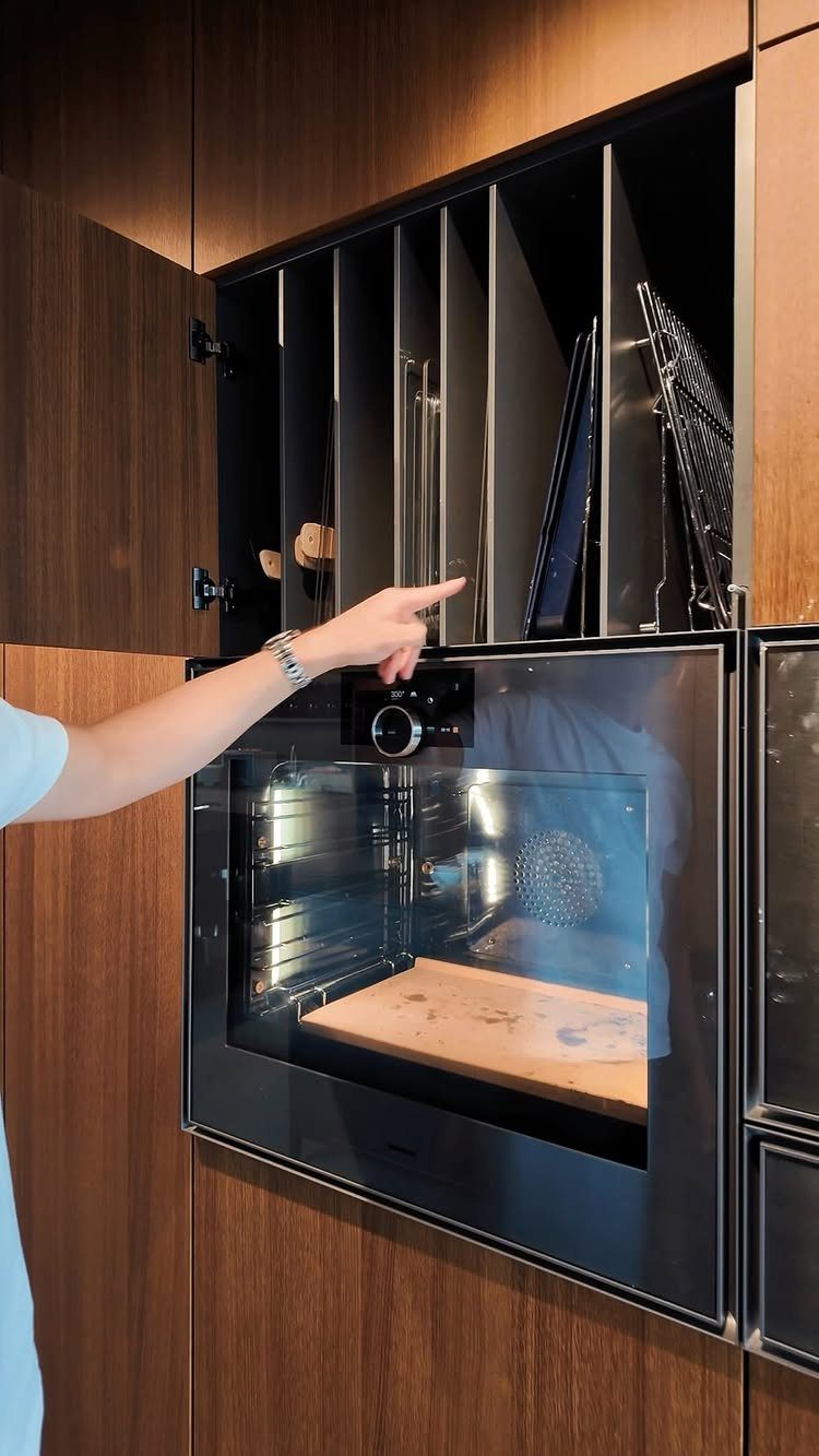 Vertical tray dividers in a dark wood cabinet above a built-in wall oven.