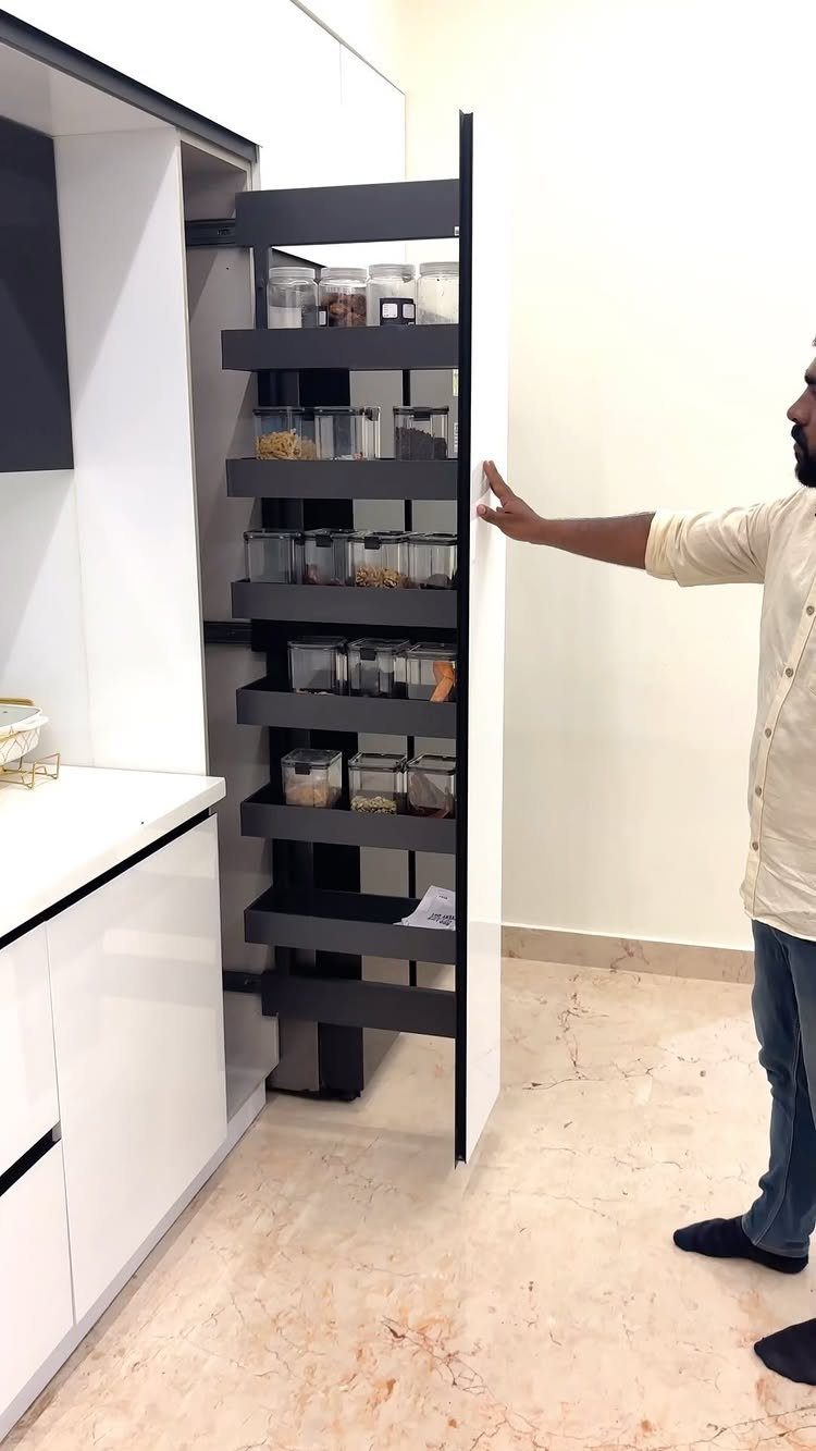 Pull Out Counter Ideas: 8 Ways to Add Kitchen Work Space 8 Tall grey pull-out shelving unit with storage containers in a white kitchen.