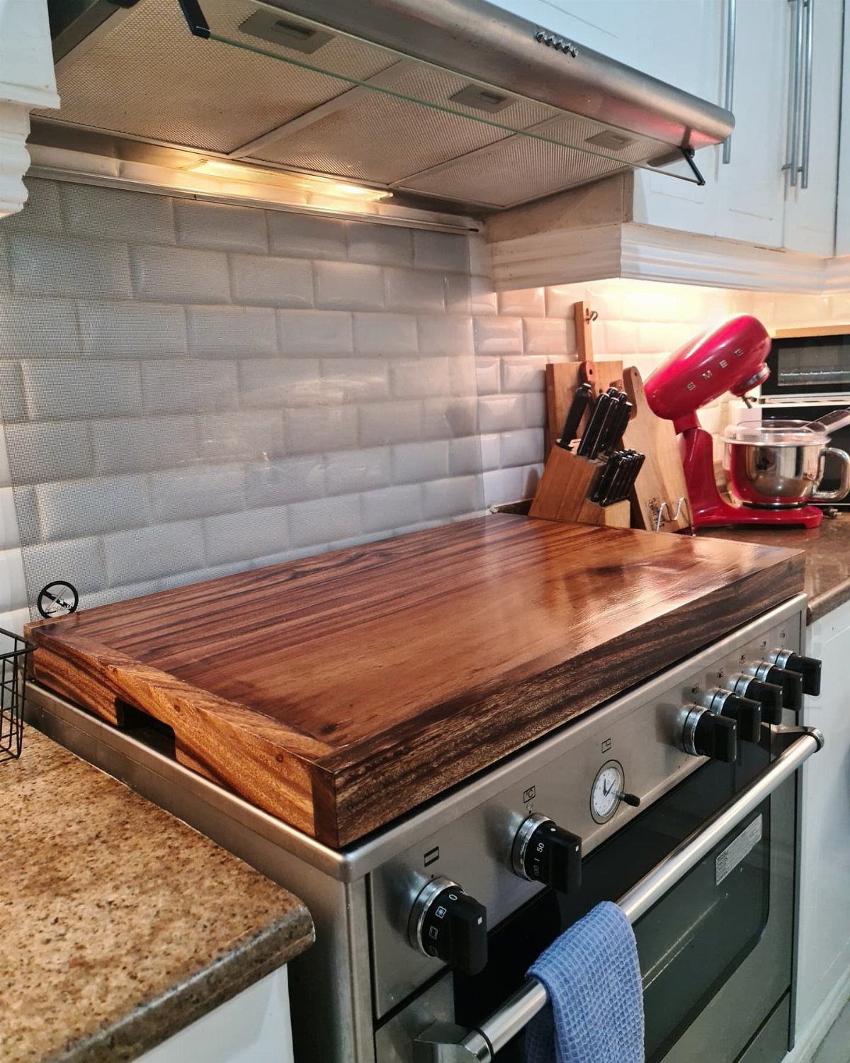 Pull Out Counter Ideas: 8 Ways to Add Kitchen Work Space 5 Wooden stove top cover creating extra counter space on a stainless steel range.