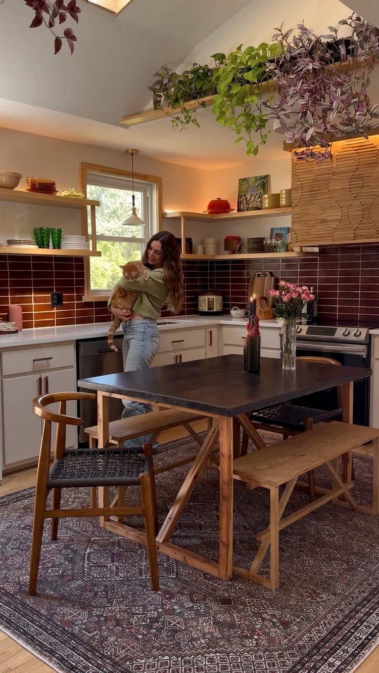 19 Small Kitchen Reno Ideas That Maximize Every Inch 16 Patterned grey and red area rug under a wooden dining table in a kitchen.