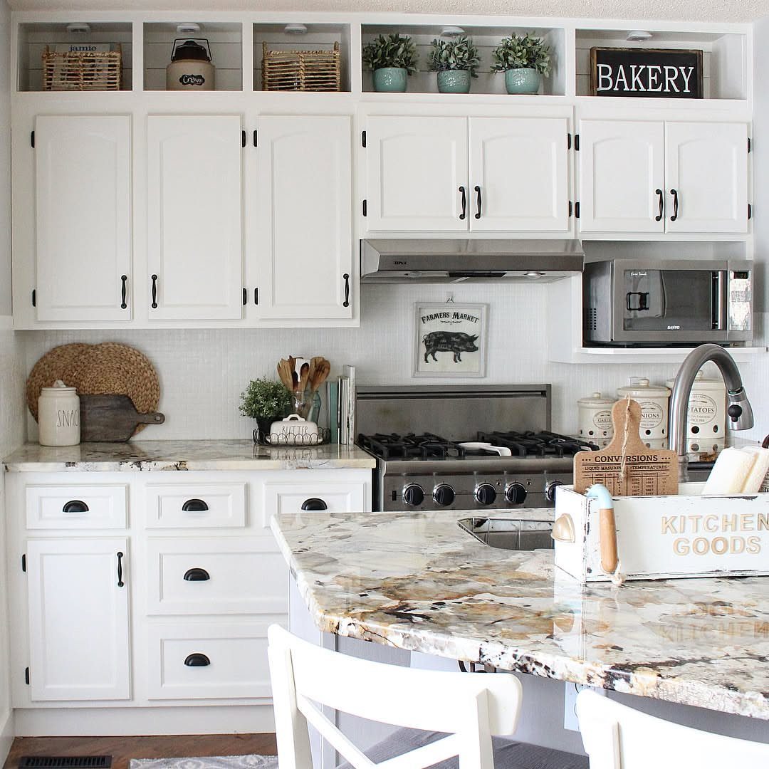 19 Small Kitchen Reno Ideas That Maximize Every Inch 15 White kitchen cabinets with built-in storage cubbies containing baskets and plants above them.
