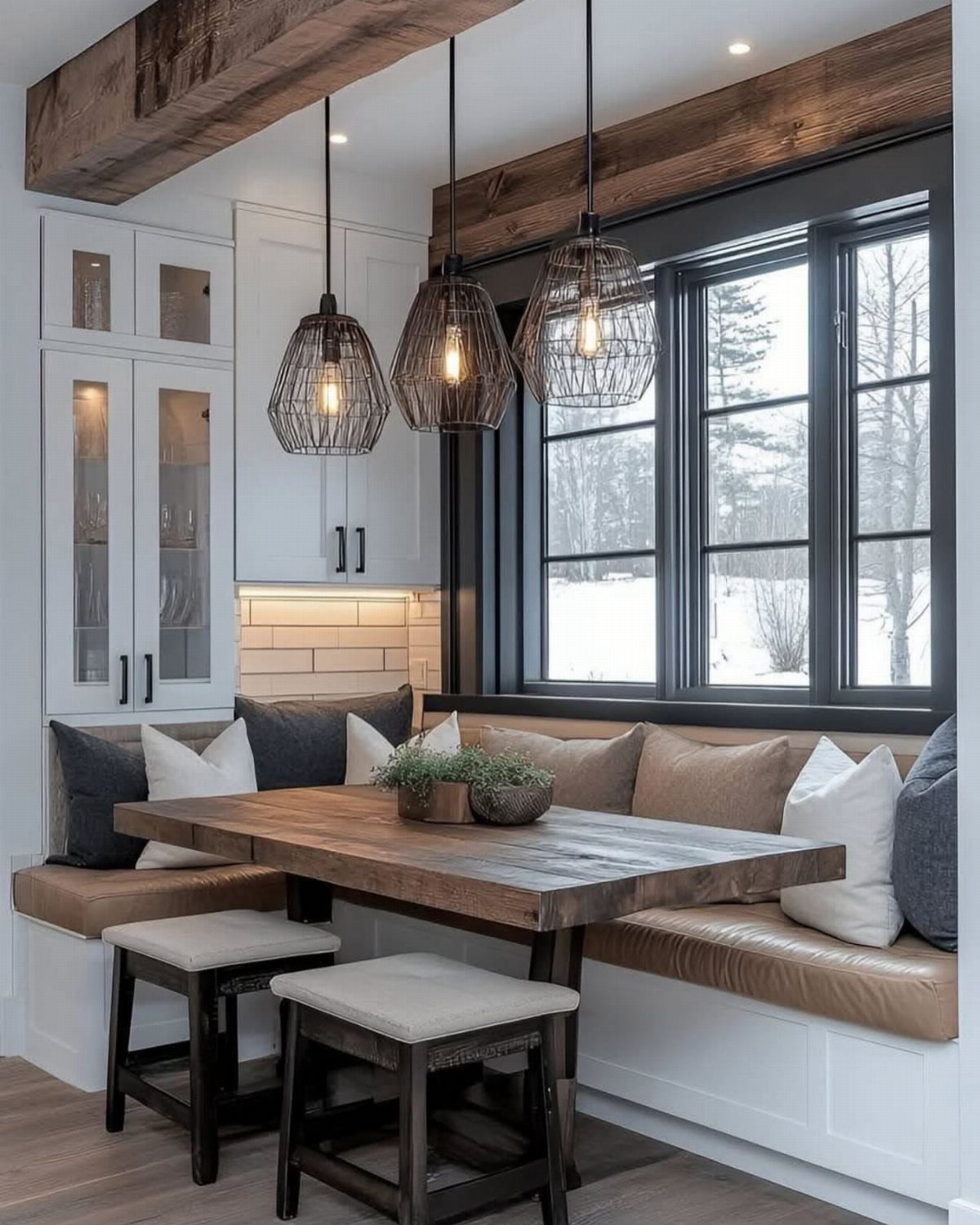 Wooden dining table with L-shaped leather banquette seating in a bright breakfast nook.