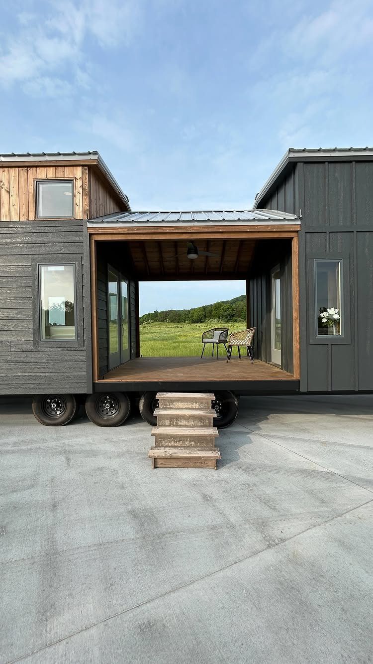 Tiny House Layout Ideas: 27 Smart Ways to Maximize Space 20 Modern tiny house with a recessed covered deck and wooden steps on pavement.