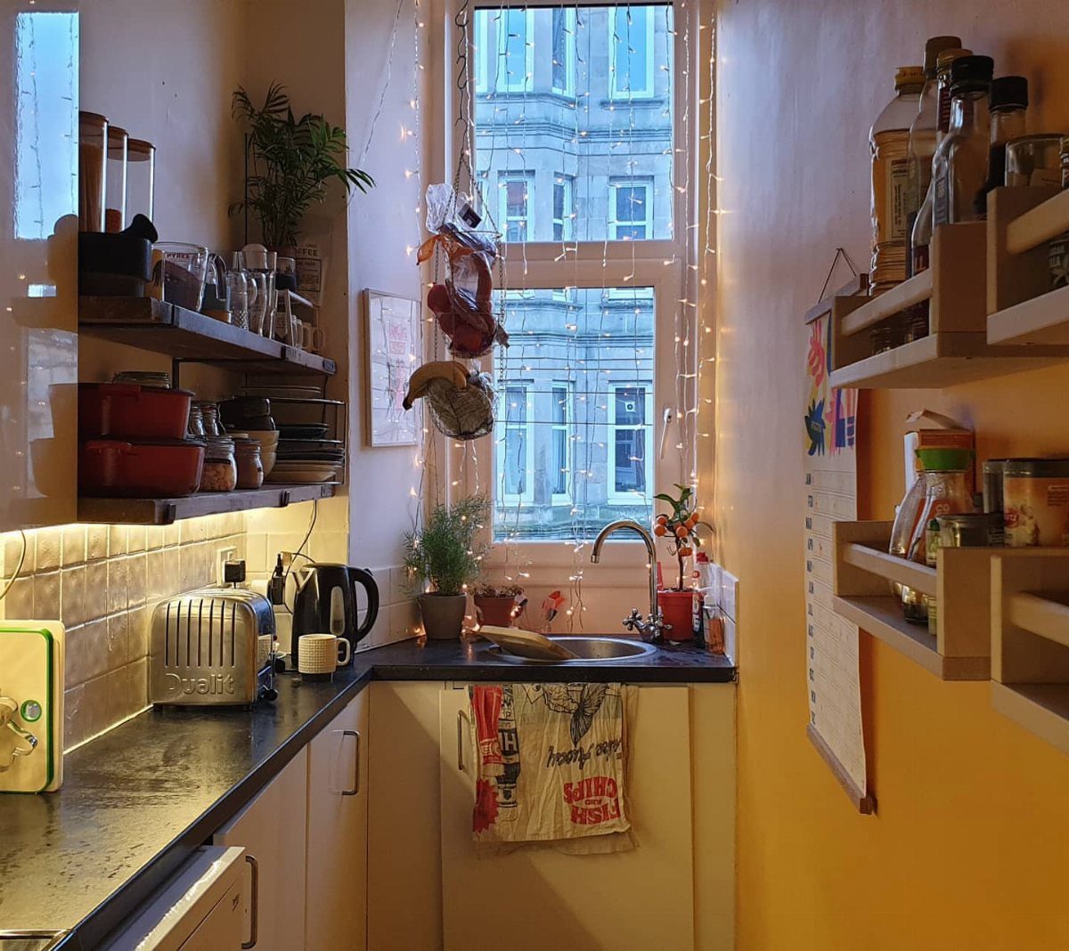 Tiny House Layout Ideas: 27 Smart Ways to Maximize Space 5 Narrow galley kitchen with black countertops, white cabinets, and open wooden shelving.