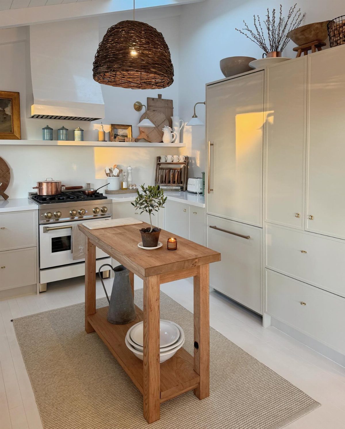 Tiny House Layout Ideas: 27 Smart Ways to Maximize Space 12 Wooden kitchen island in a small white kitchen with a woven pendant light.