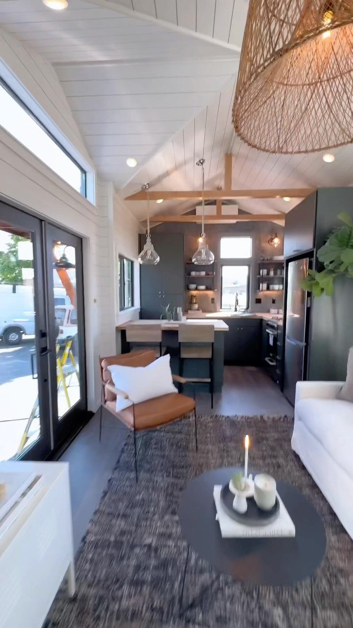 Tiny House Layout Ideas: 27 Smart Ways to Maximize Space 2 Tiny house interior with open-concept living area and dark grey kitchen with island.