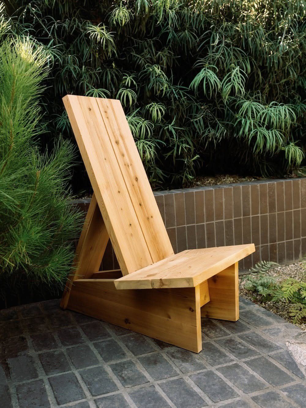 Wood Lounge Chair Ideas: 28 Styles from Teak to Mid-Century 14 Light wood lounge chair with a high back on a grey tiled patio.