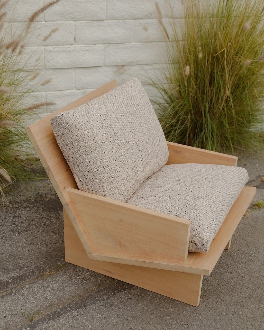 Wood Lounge Chair Ideas: 28 Styles from Teak to Mid-Century 21 Plank outdoor chair made of light wood with cream textured cushions against a brick wall.