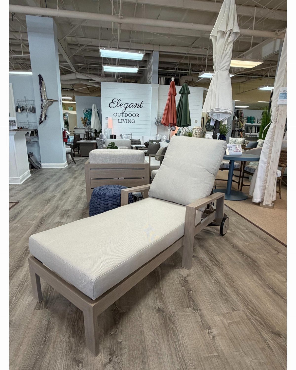 Wood Lounge Chair Ideas: 28 Styles from Teak to Mid-Century 15 Wooden chaise lounge with white cushions and wheels in a furniture showroom