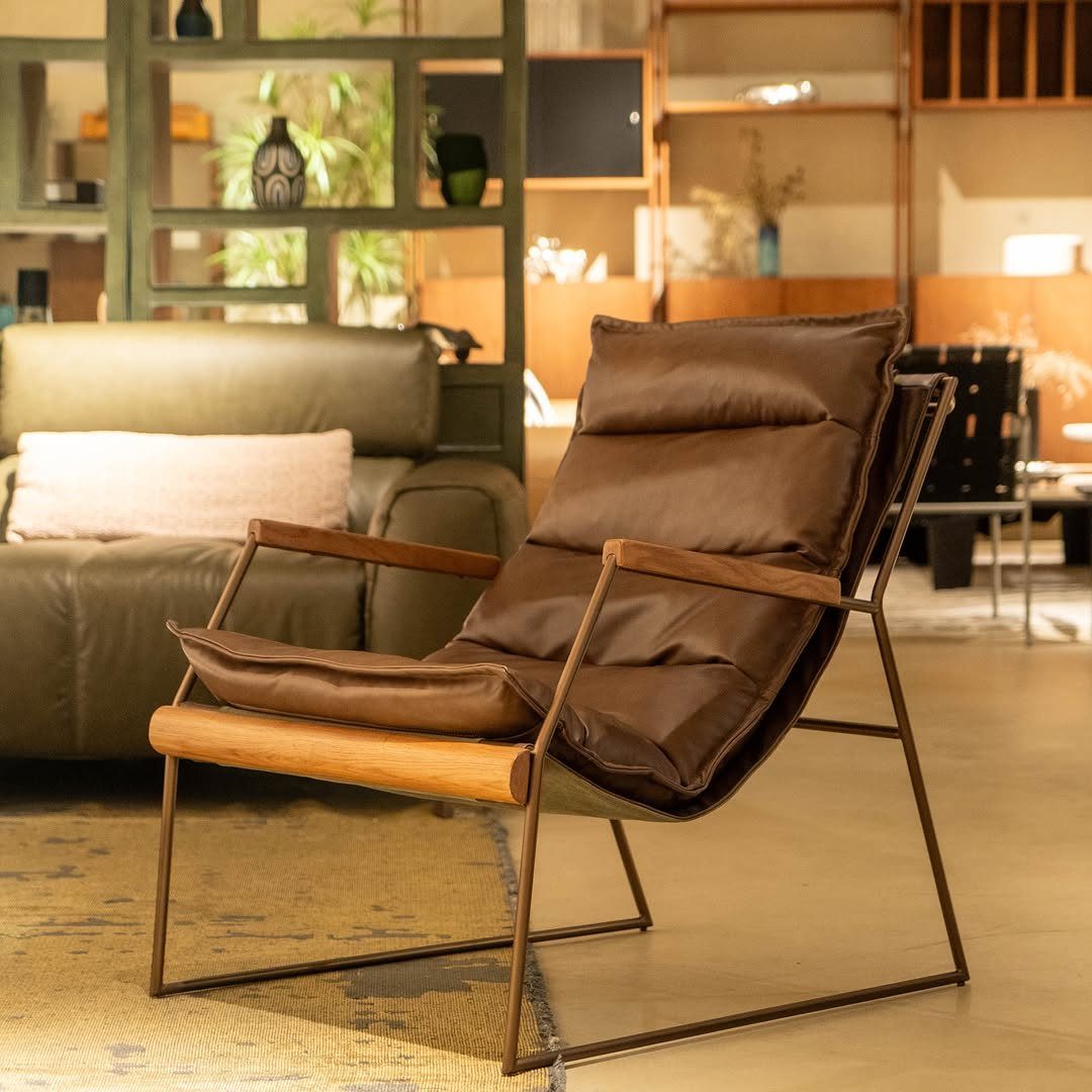 Wood Lounge Chair Ideas: 28 Styles from Teak to Mid-Century 26 Brown leather lounge chair with a dark metal frame and wooden armrests.